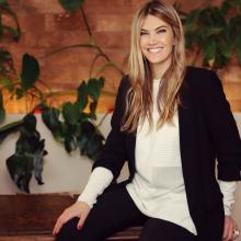 Eva Kaili sitting and smiling at the camera